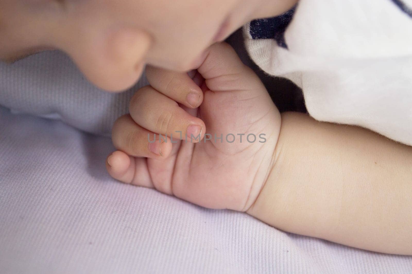 Two month old baby hand. Blue background