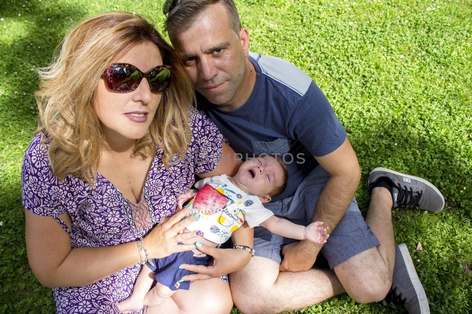 Family sitting on the grass. Summer day