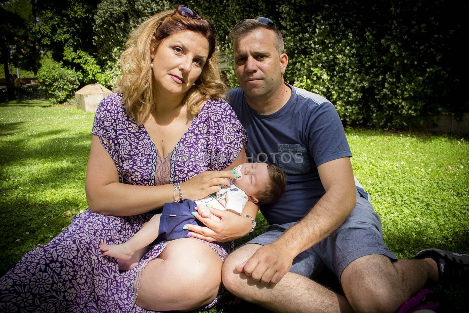 Family sitting on the grass. Summer day