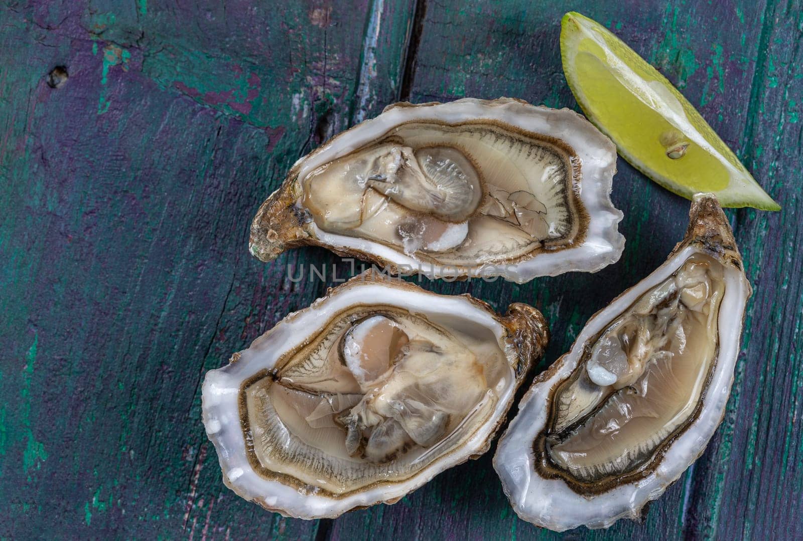 Close up of three oyesters open on wooden background, gourmet macro food photography by JPC-PROD