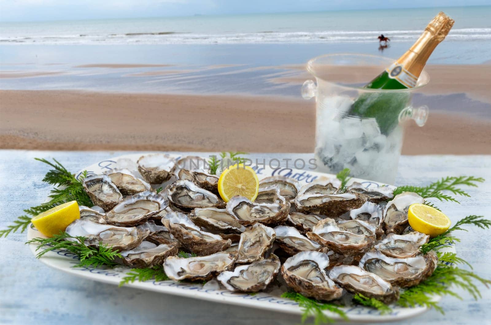 big Oysters plate and botle of champagne wine in a restaurant with a sea view by JPC-PROD