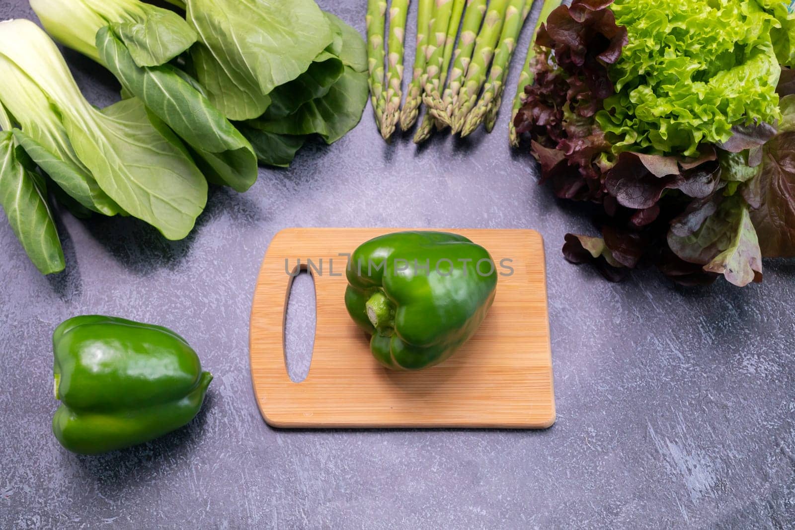 Top View Assortment Of Fresh Organic Vegetables, Green Bell Pepper On Cutting Board On Table. Asparagus Plant, Bok Choy, Red Leaf Lettuce. Healthy Bio Food, Longevity Diet. Horizontal Plane by netatsi