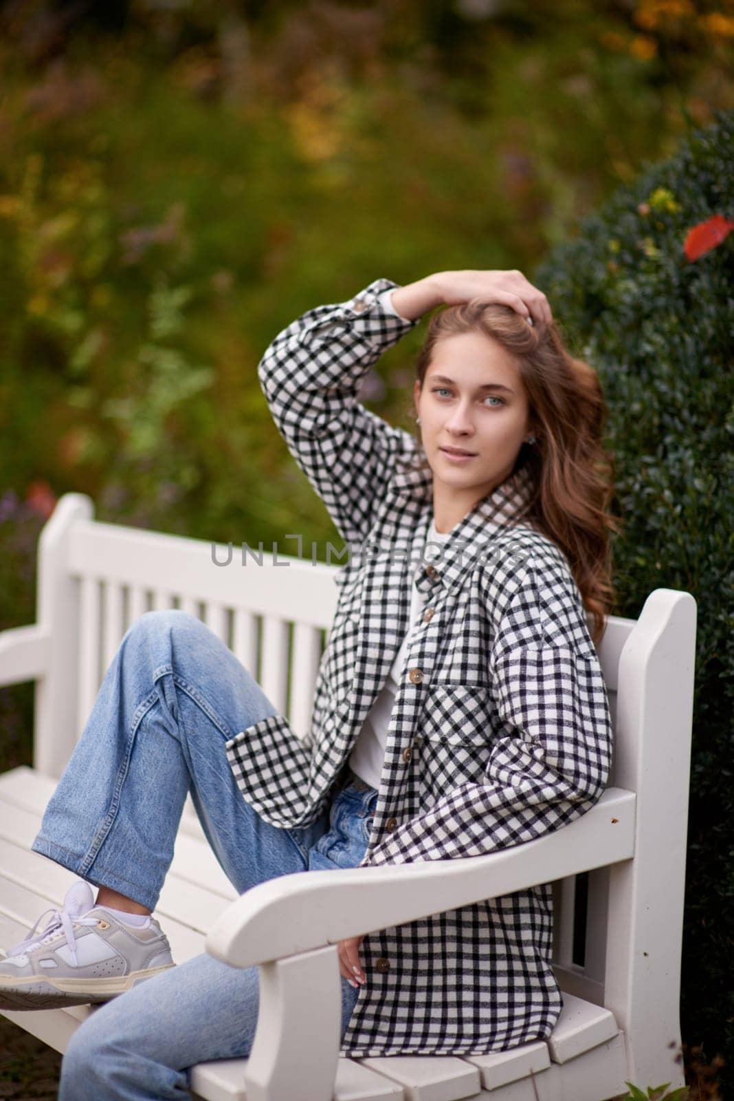 Charming Autumn Casual: Beautiful Girl on Park Bench. Autumn Grace: Stylish Casual Amidst Fall Foliage. Casual Chic in Autumn: Beauty on a Park Bench by Andrii_Ko