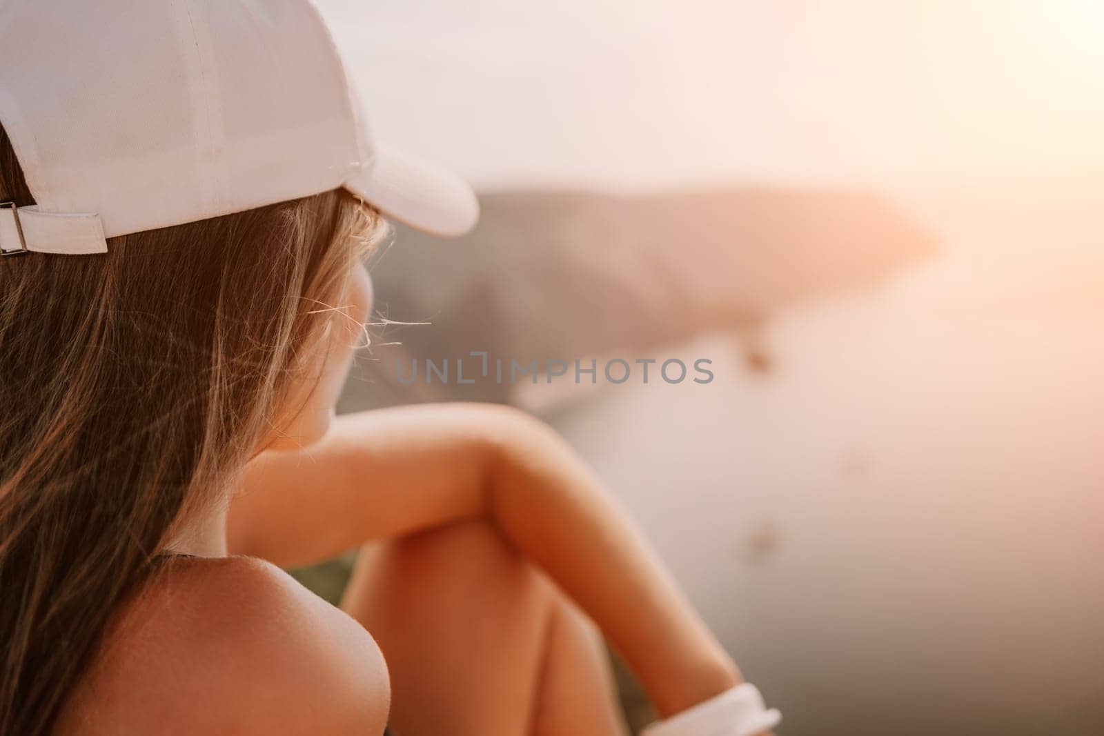 Woman travel sea. Happy tourist taking picture outdoors for memories. Woman traveler looks at the edge of the cliff on the sea bay of mountains, sharing travel adventure journey.