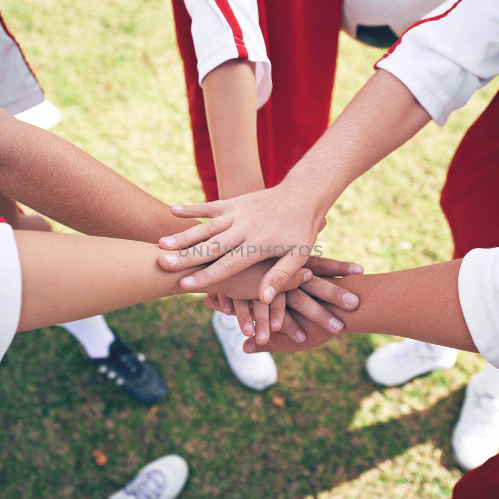 Hands, huddle and solidarity in children soccer team, team building and collaboration or support in circle. People, group and teamwork or partnership and trust in community, unity and connection by YuriArcurs