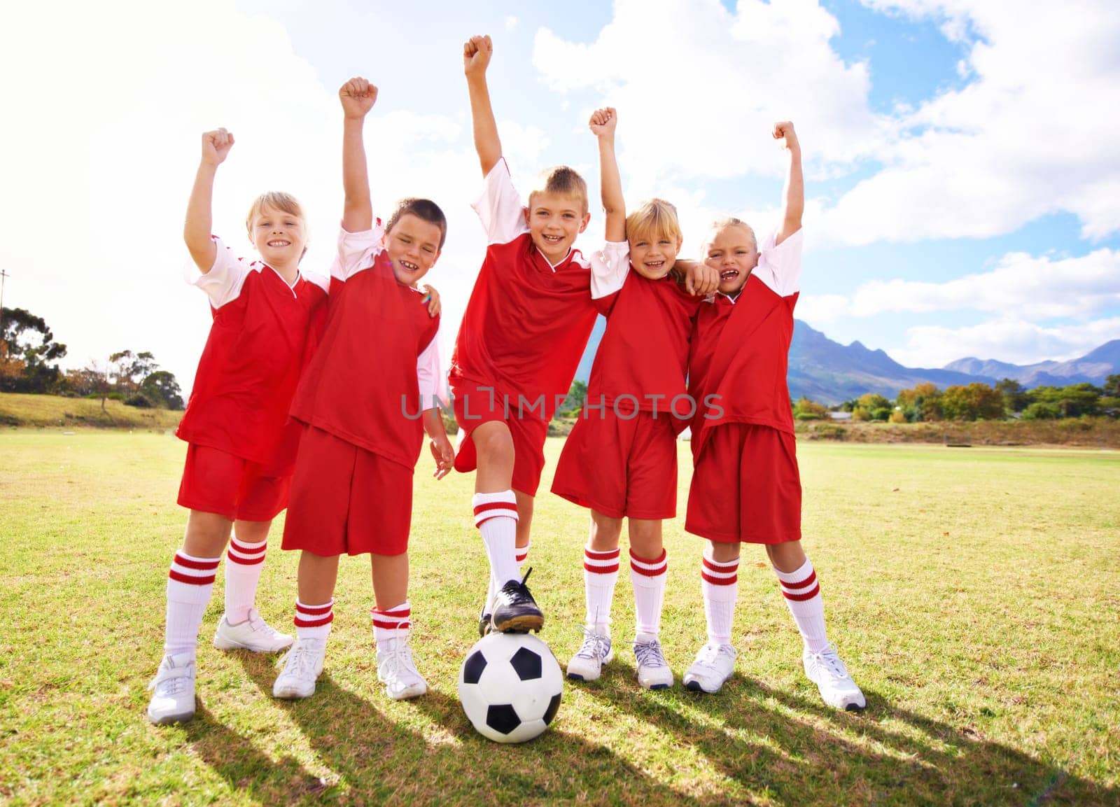 Children, soccer team and celebration for winning or success, happy and victory in outdoors. People, kids and fist pump for achievement, collaboration and partnership or teamwork on field or sport.