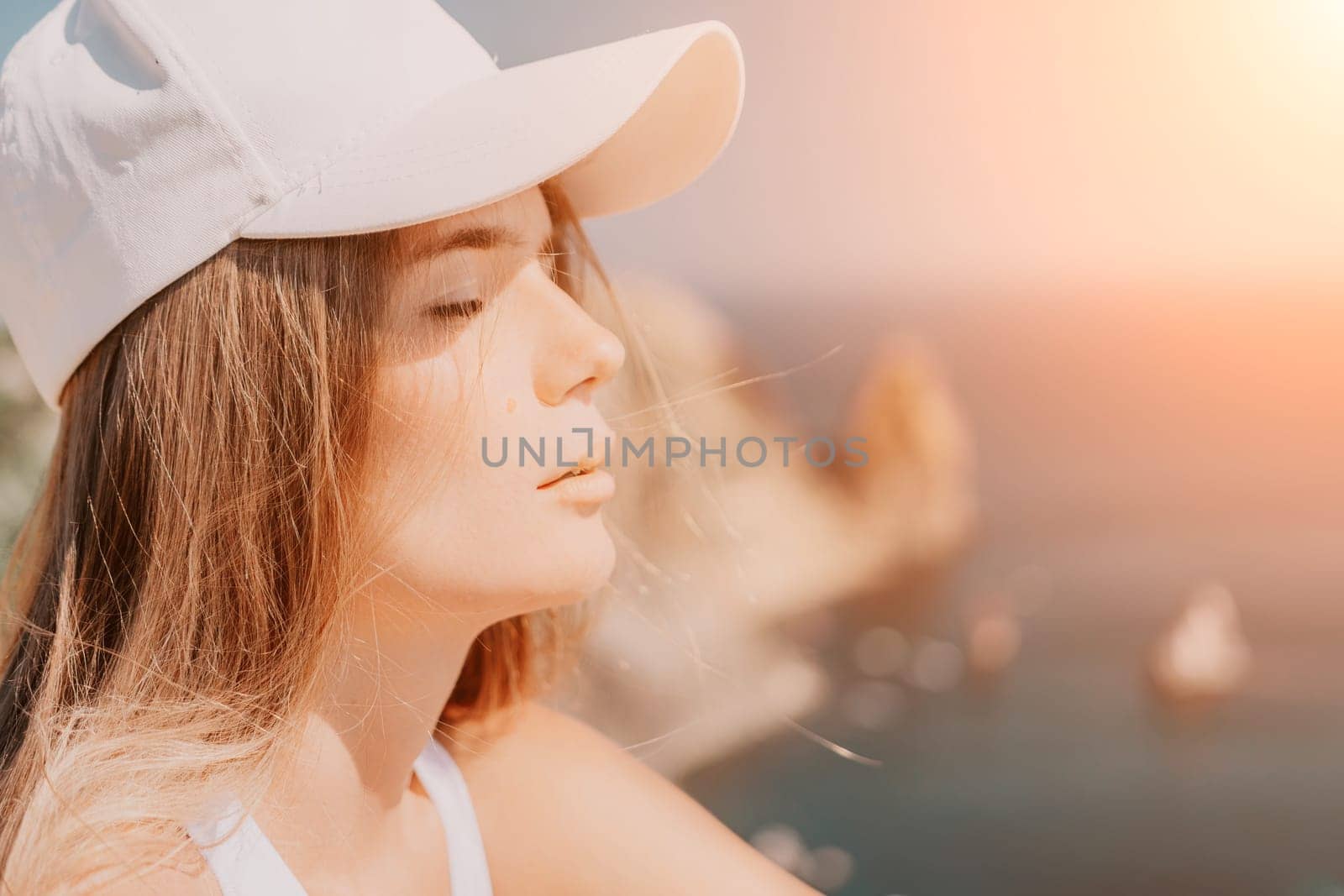 Woman travel sea. Young Happy woman in a long red dress posing on a beach near the sea on background of volcanic rocks, like in Iceland, sharing travel adventure journey