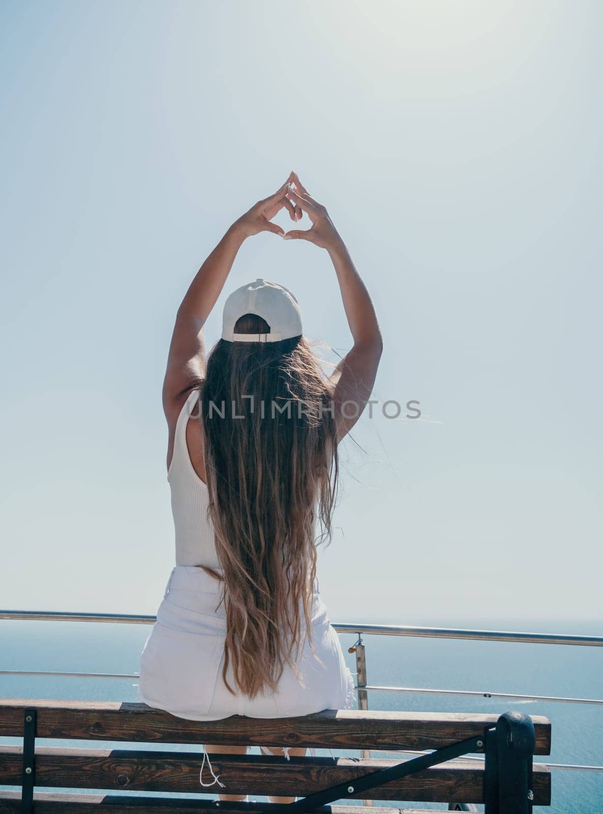 Woman summer travel sea. Happy tourist enjoy taking picture outdoors for memories. Woman traveler posing over sea bay surrounded by volcanic mountains, sharing travel adventure journey by panophotograph