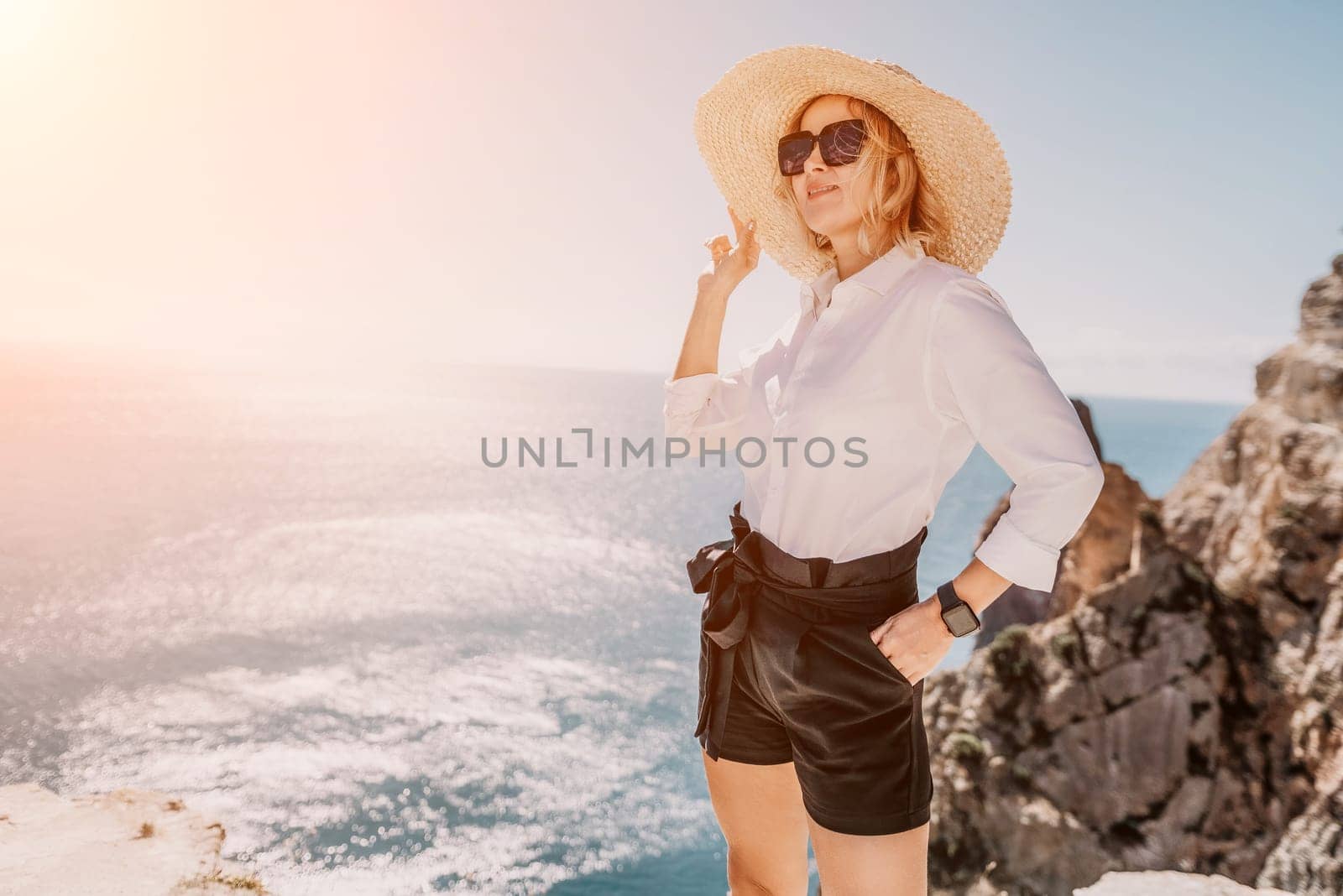 Woman sea laptop. Business woman in yellow hat freelancer with laptop working over blue sea beach. Girl relieves stress from work. Freelance, digital nomad, travel and holidays concept by panophotograph