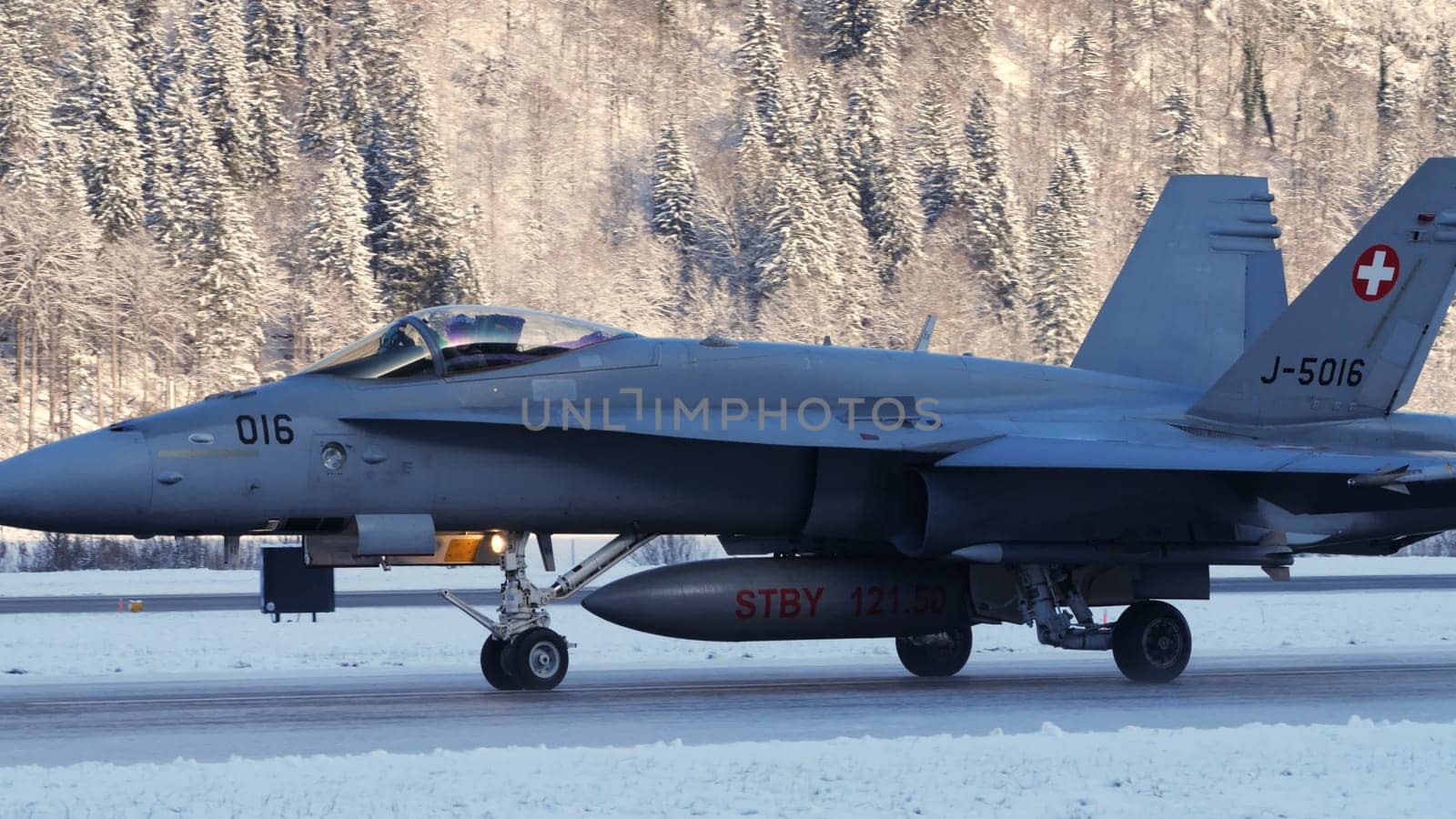 Meiringen Switzerland January 19 2023: Fighter jet taxiing in white winter snow scenario. Copy Space. Boeing F-18 Hornet of Swiss Air Force air defense for World Economic Forum WEF in Davos.