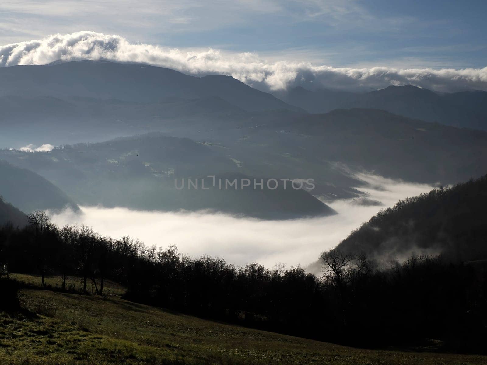 low clouds like fog in appennines valley around Bismantova stone a rock formation in the Tuscan-Emilian Apennines (Italy).