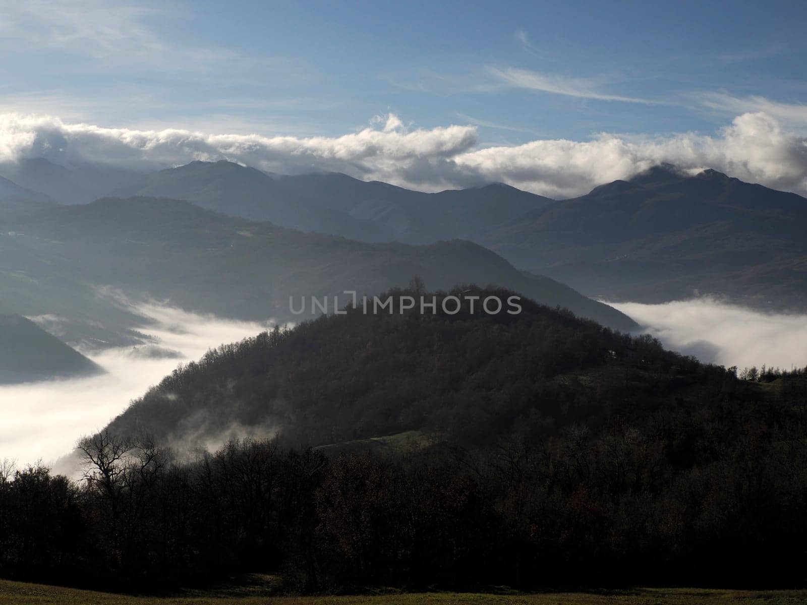 low clouds like fog in appennines valley around Bismantova stone a rock formation in the Tuscan-Emilian Apennines (Italy) by AndreaIzzotti