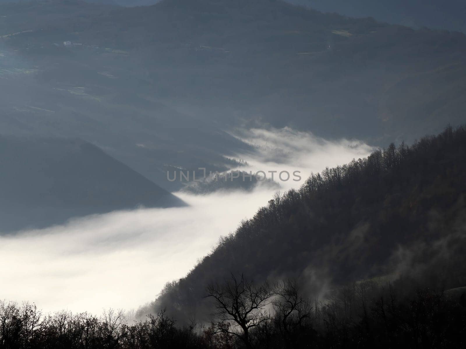 low clouds like fog in appennines valley around Bismantova stone a rock formation in the Tuscan-Emilian Apennines (Italy).