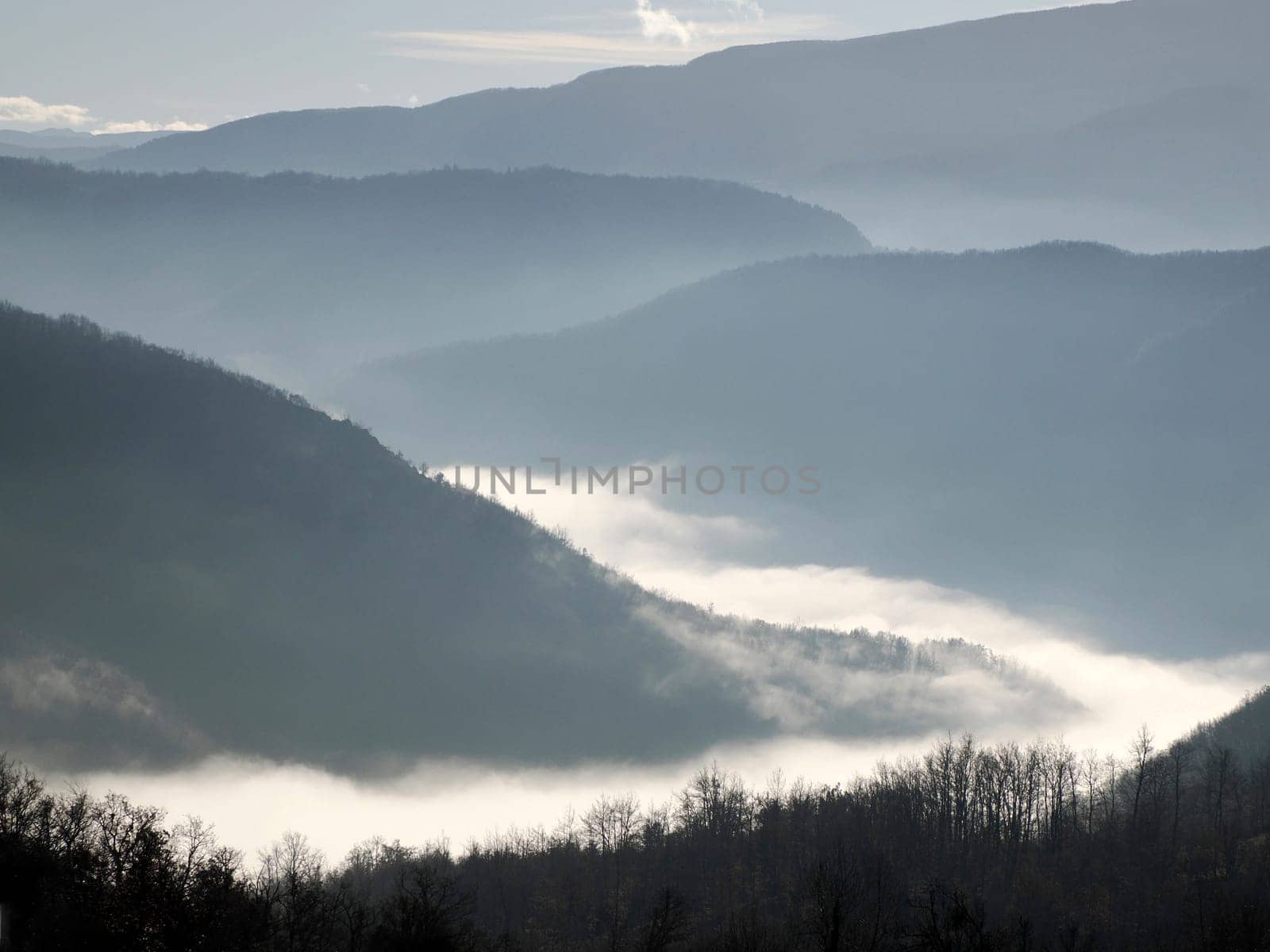 low clouds like fog in appennines valley around Bismantova stone a rock formation in the Tuscan-Emilian Apennines (Italy).