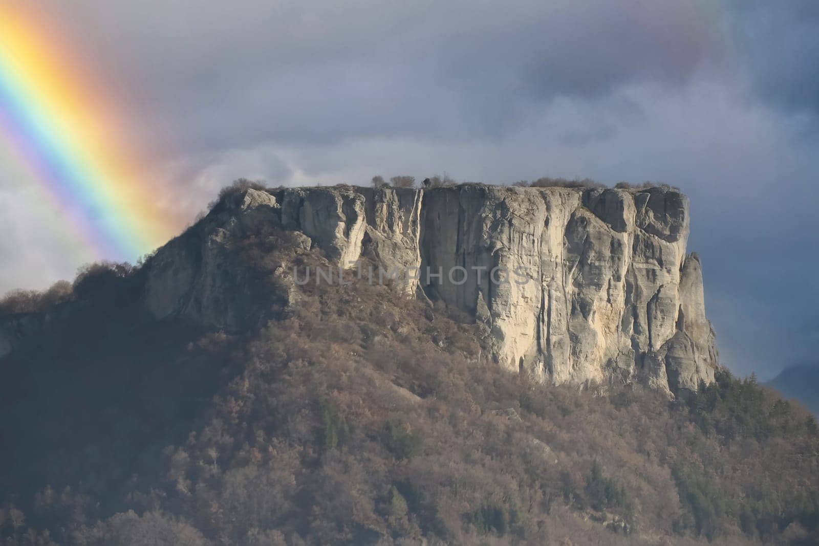 a rainbow over Bismantova stone a rock formation in the Tuscan-Emilian Apennines (Italy) by AndreaIzzotti