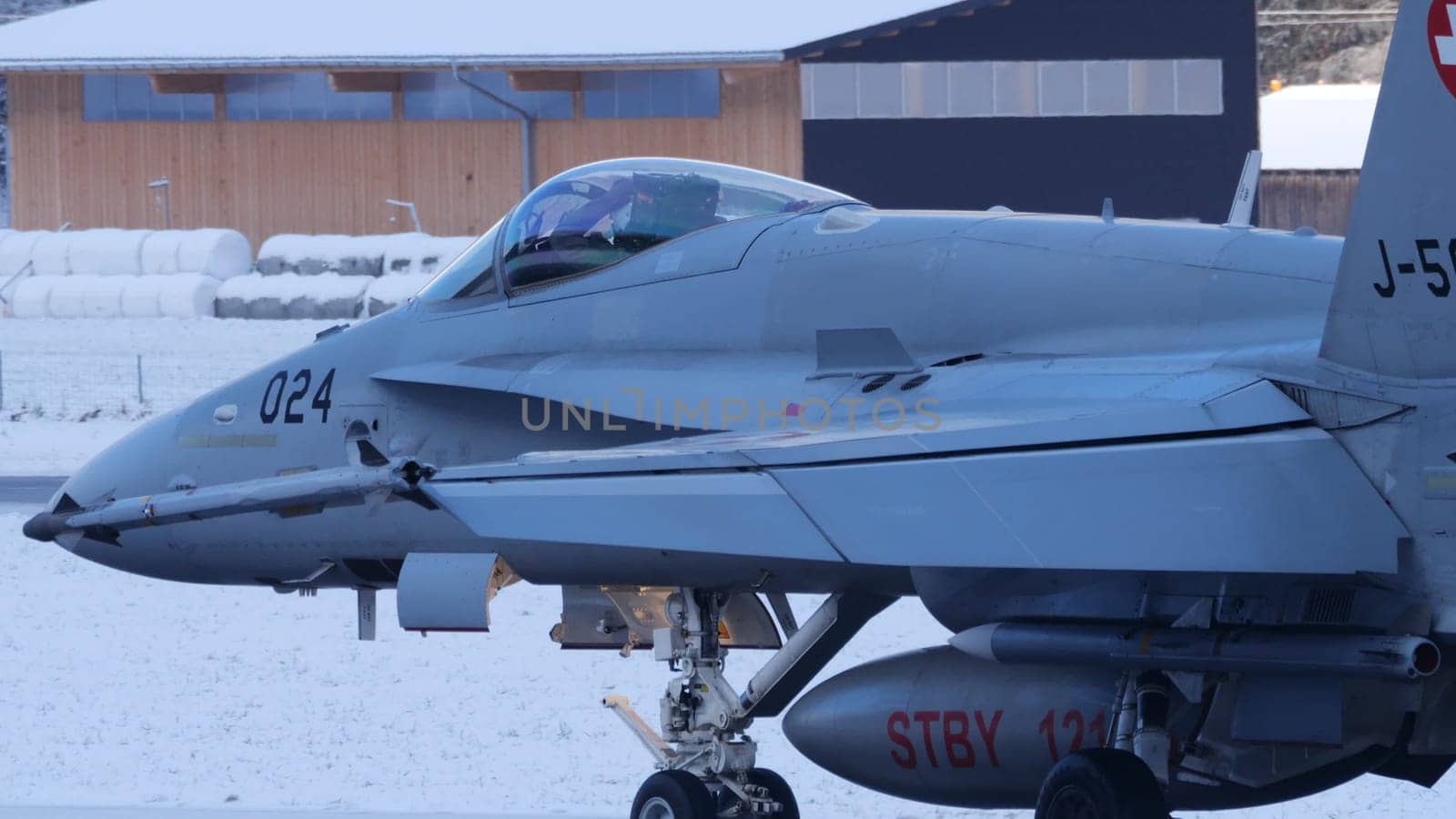 Meiringen Switzerland January 19 2023: Close up of military fighter jet taxiing on snow landscape. Air defense of World Economic Forum WEF in Davos. Copy Space. Boeing F-18 Hornet of Swiss Air Force