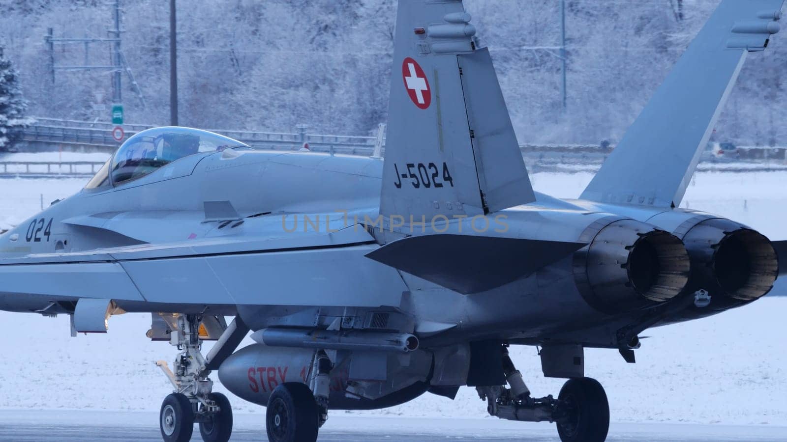 Meiringen Switzerland January 19 2023: Close up of military fighter jet taxiing on snow landscape. Air defense of World Economic Forum WEF in Davos. Copy Space. Boeing F-18 Hornet of Swiss Air Force