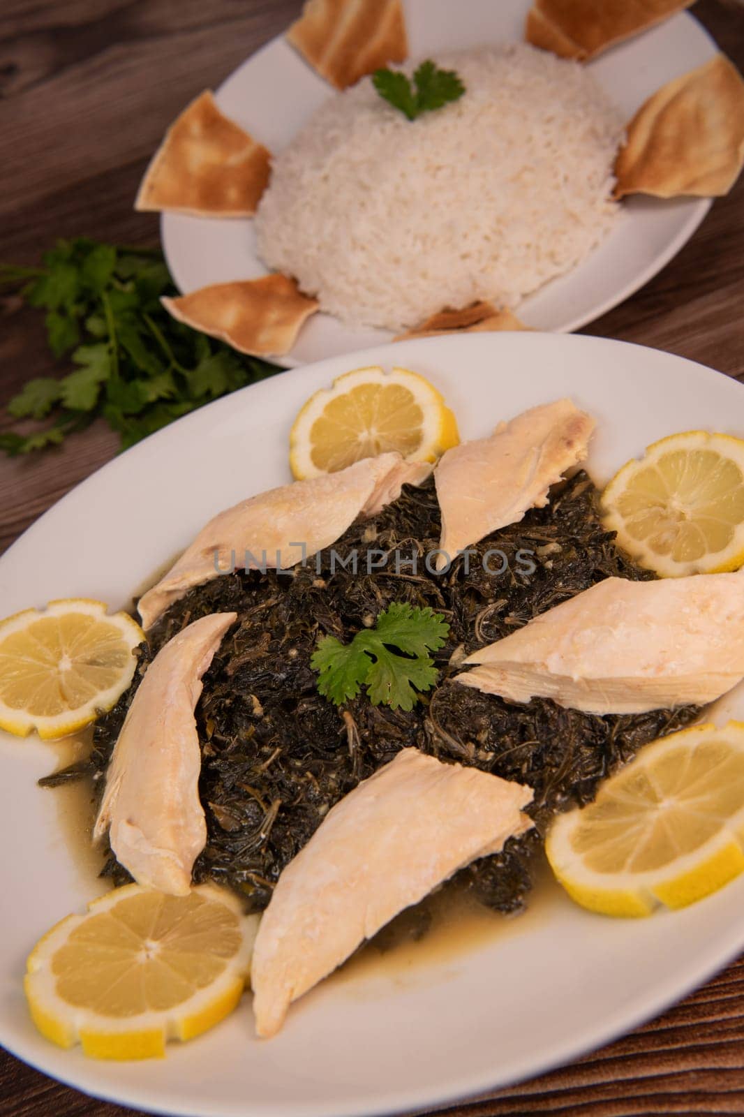 Lebanese recipe Mouloukhia , Melokhiyah, corete leaf and coriander rice chicken, grilled pita. High quality photo