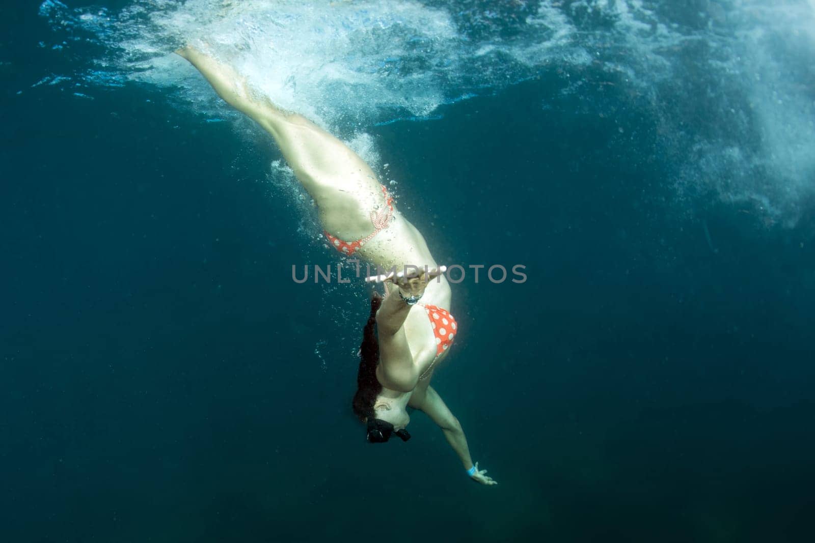 beautiful girl swimming under a ship by AndreaIzzotti