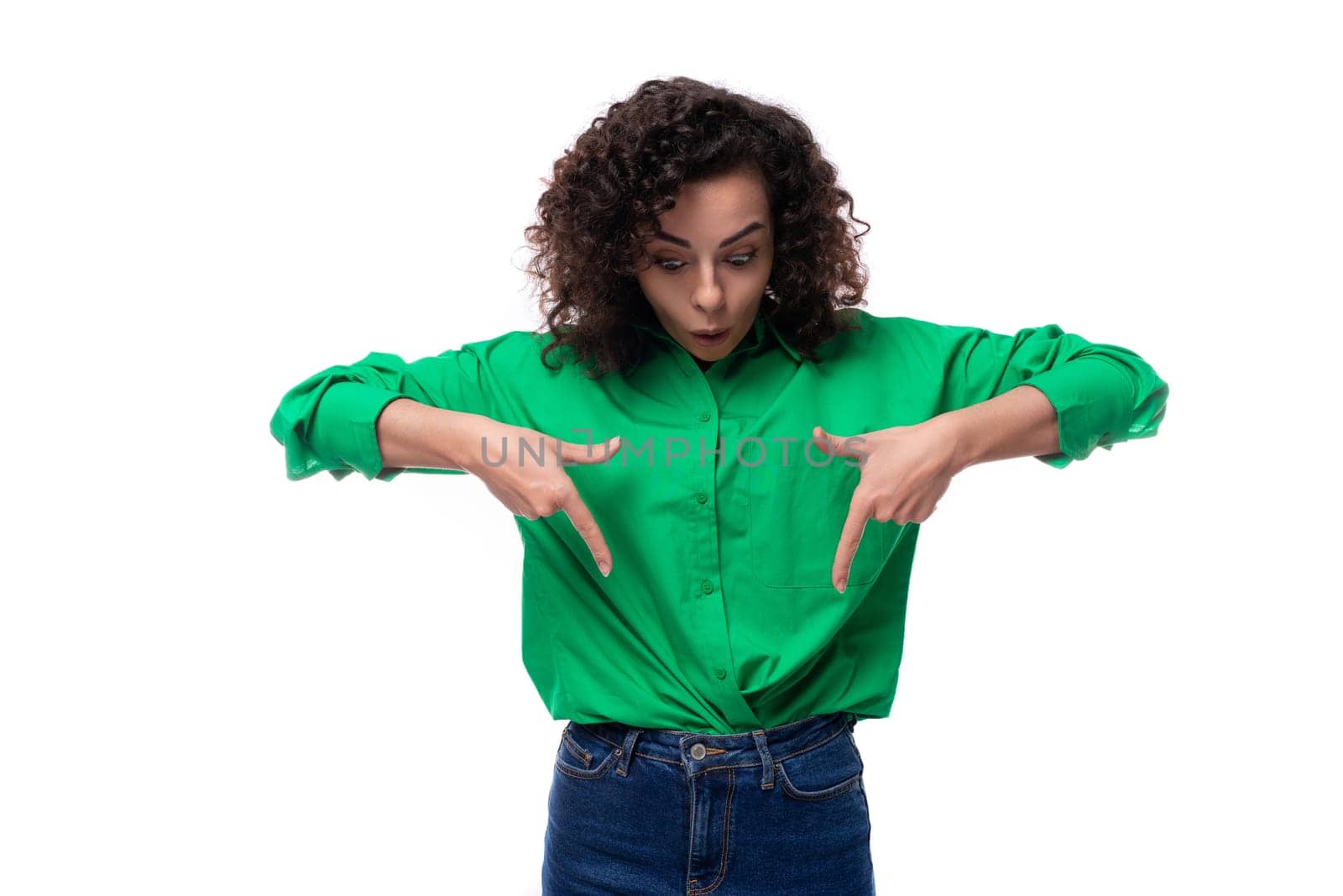 young active european brunette woman with curly hairstyle in green shirt works in an advertising agency.