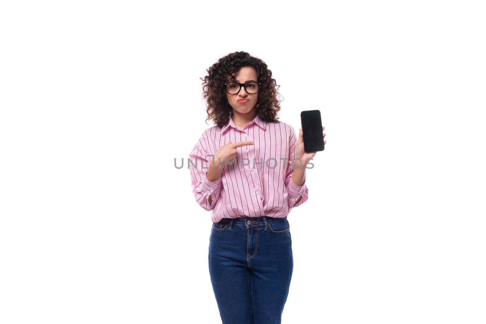 young charming caucasian woman with curly hair dressed in a striped shirt advertises a phone with a mockup.