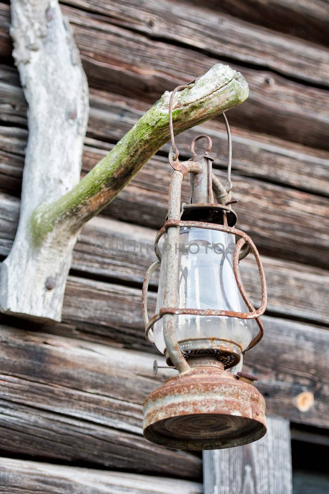 oil lamp on wooden hut background by AndreaIzzotti