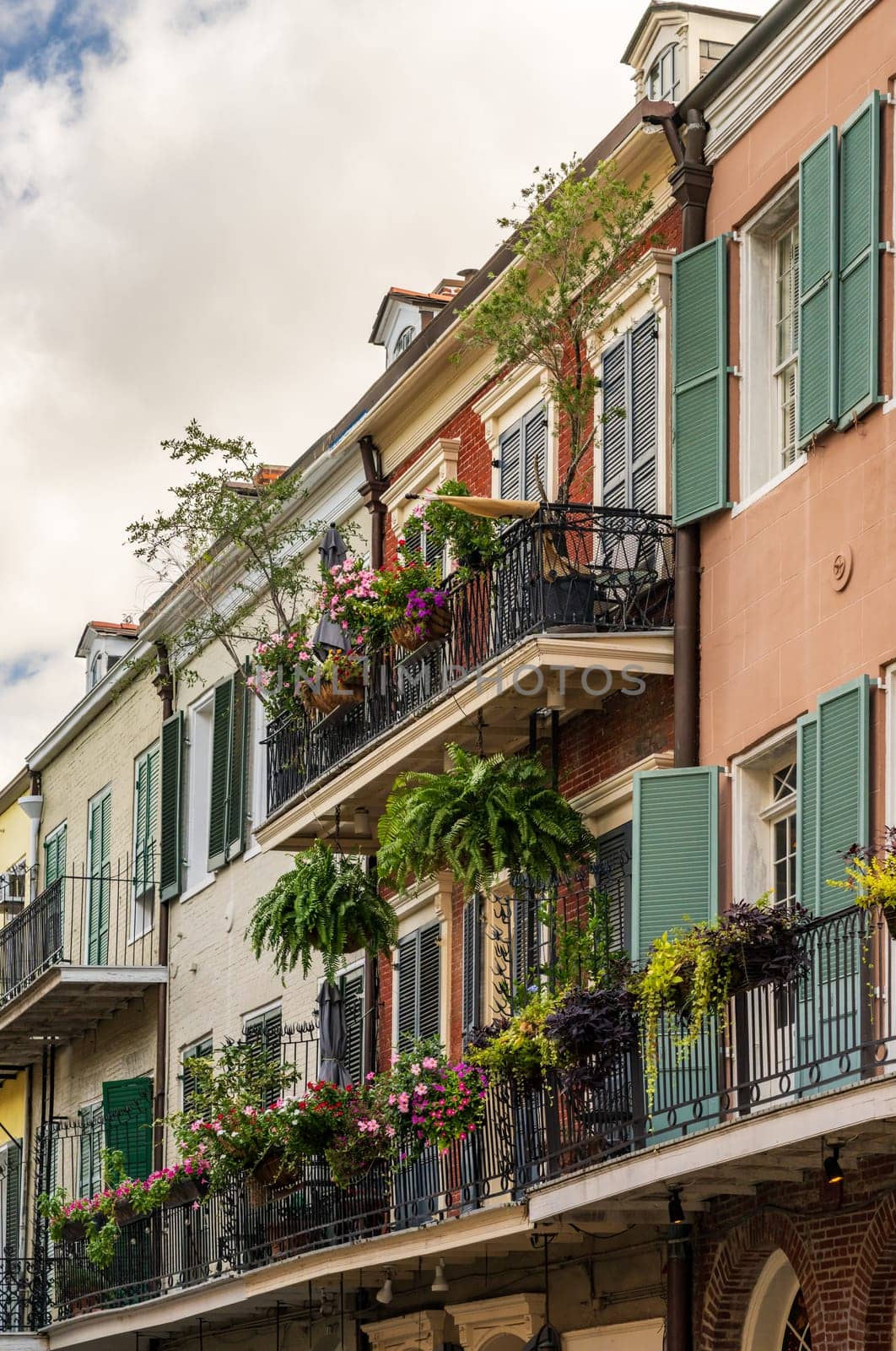 Traditional wrought iron balcony on colorful New Orleans houses by steheap