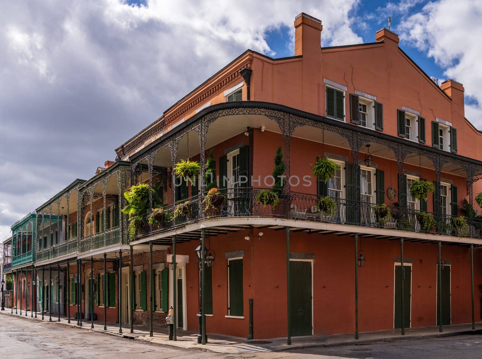 Traditional wrought iron balcony on ochre New Orleans house by steheap
