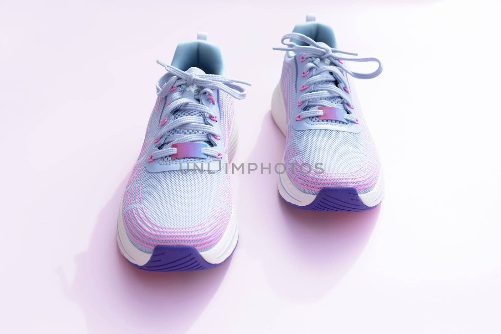 Purple Blue Female Sportive Running Shoes on Pink Background. Fashion, Training Footwear for Gym, Shoes For Woman. National Shoe The World Day. Horizontal Plane. High quality photo