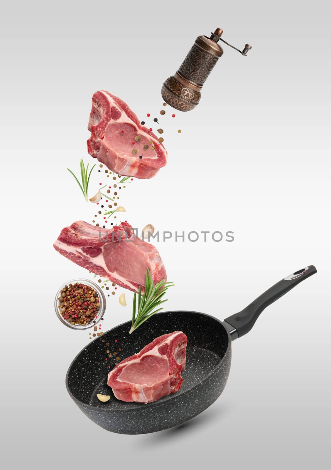 Levitating pieces of pork meat on a rib, spices. Cooking lunch