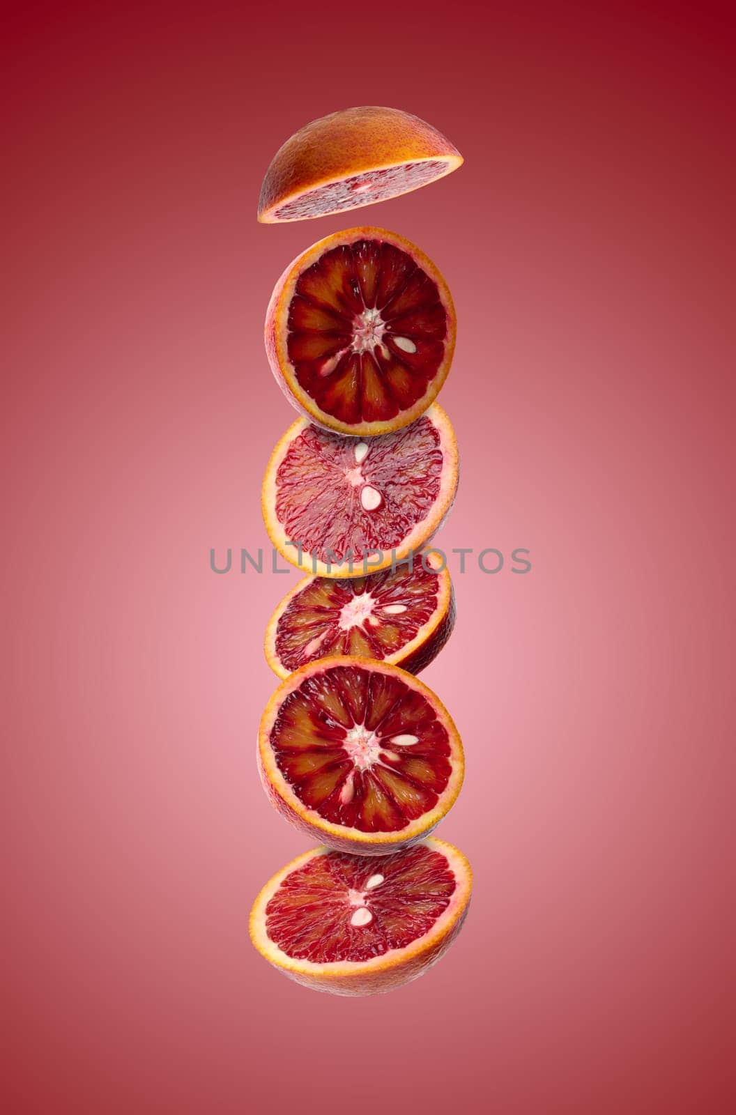 Various pieces of red orange on a red background. Fruit slices levitate