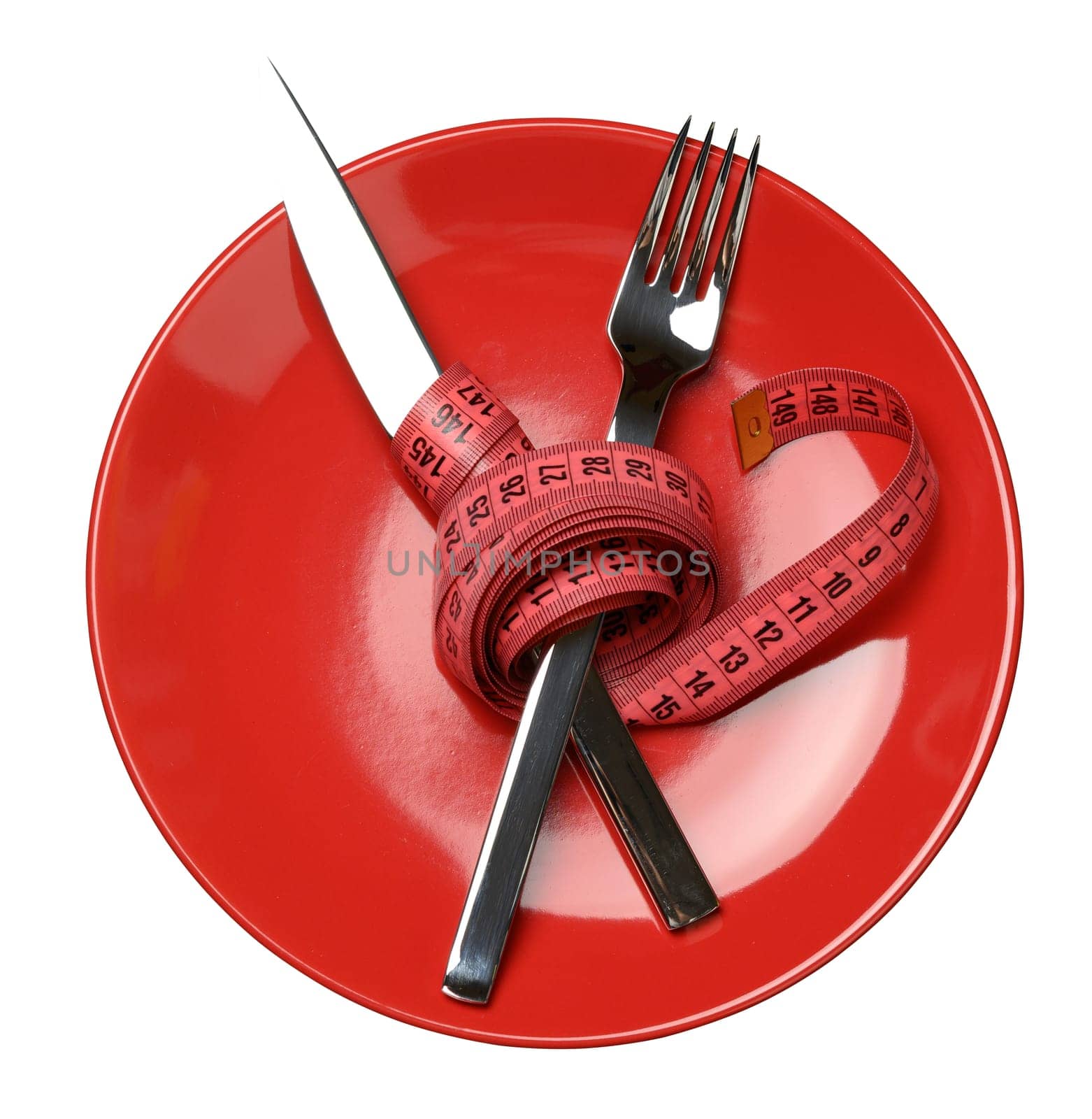 Red round plate and fork and knife wrapped in green measuring tape, weight loss concept