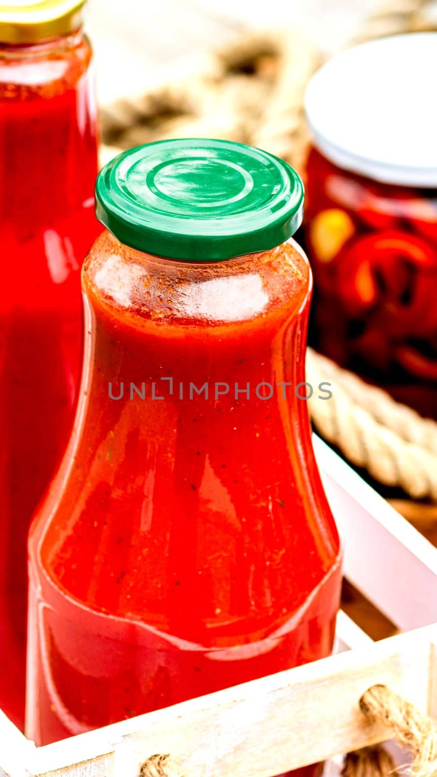 Bottles of tomato sauce, preserved canned pickled food concept isolated in a rustic composition.