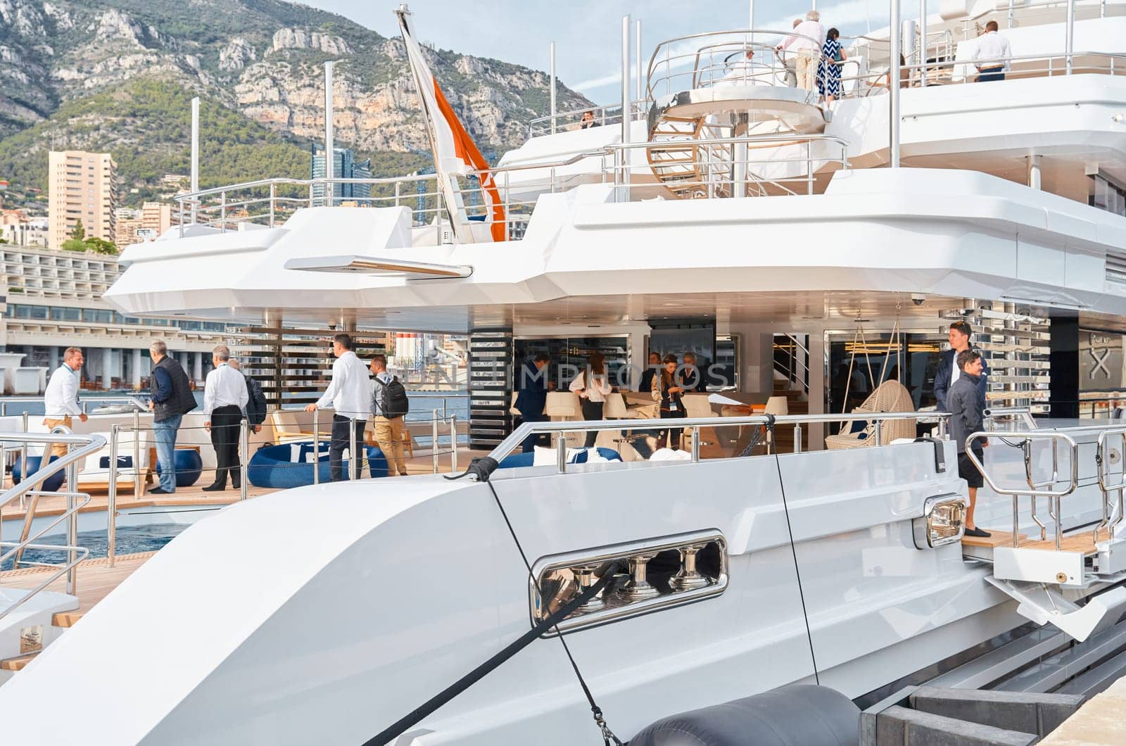 Monaco, Monte Carlo, 29 September 2022 - Invited wealthy clients inspect mega yachts at the largest fair exhibition in the world yacht show MYS, port Hercules, yacht brokers, sunny weather. High quality photo