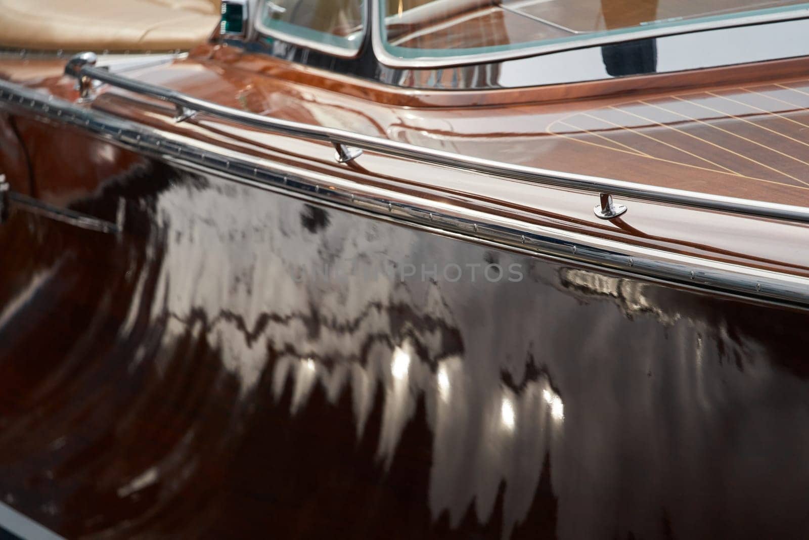 the wooden side of the luxury motor boat in port of Hercules in Monaco, sunny glare of the sun, elegance boat, glossy surfaces shine in sunny weather. High quality photo