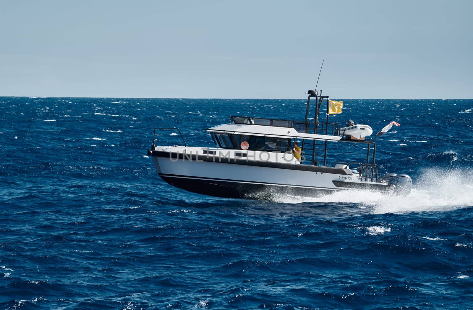 Monaco, Monte Carlo, 28 September 2022 - A motorboat with people is sailing at high speed in the sea near Monaco, island on background. High quality photo