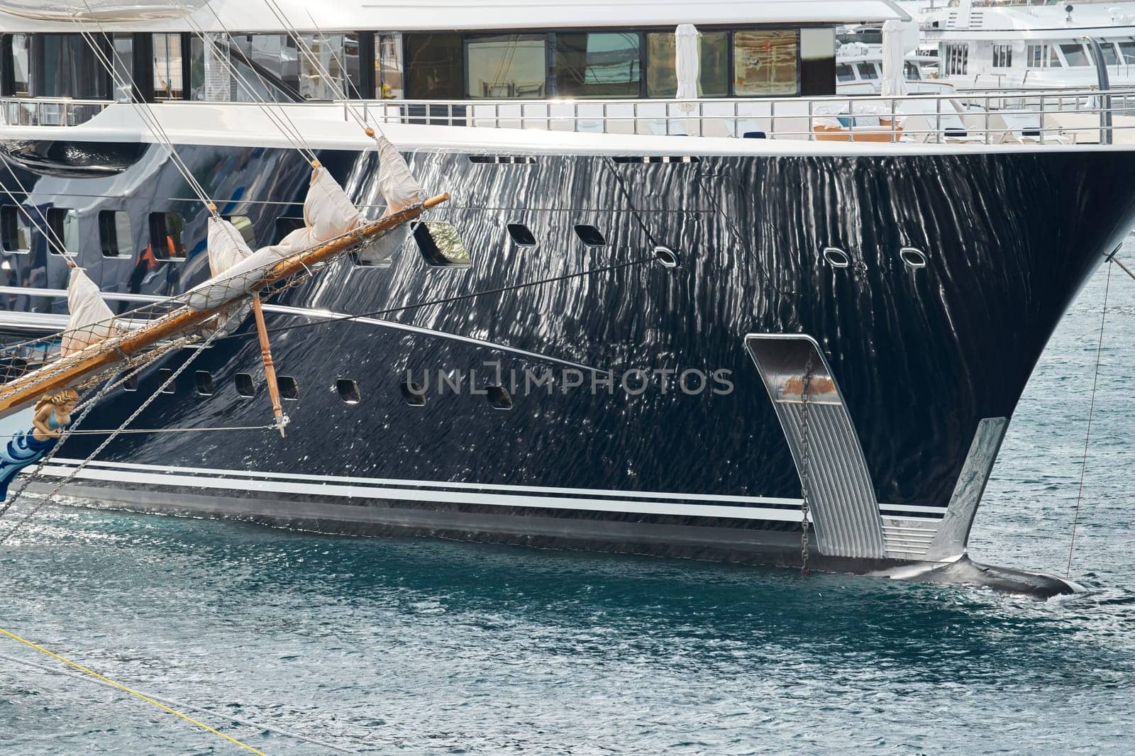 Sun glare on glossy board of mega yacht, anchor, tranquillity in port Hercules, bow of moored huge boat at sunny day, Monaco, Monte-Carlo by vladimirdrozdin