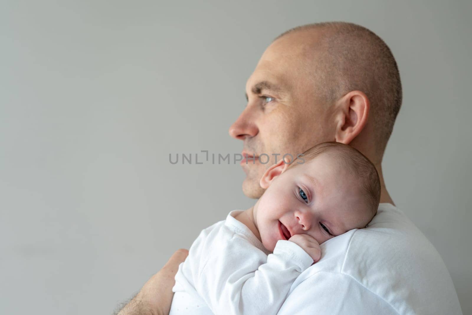 Father holds a baby in his arms. Parental care concept