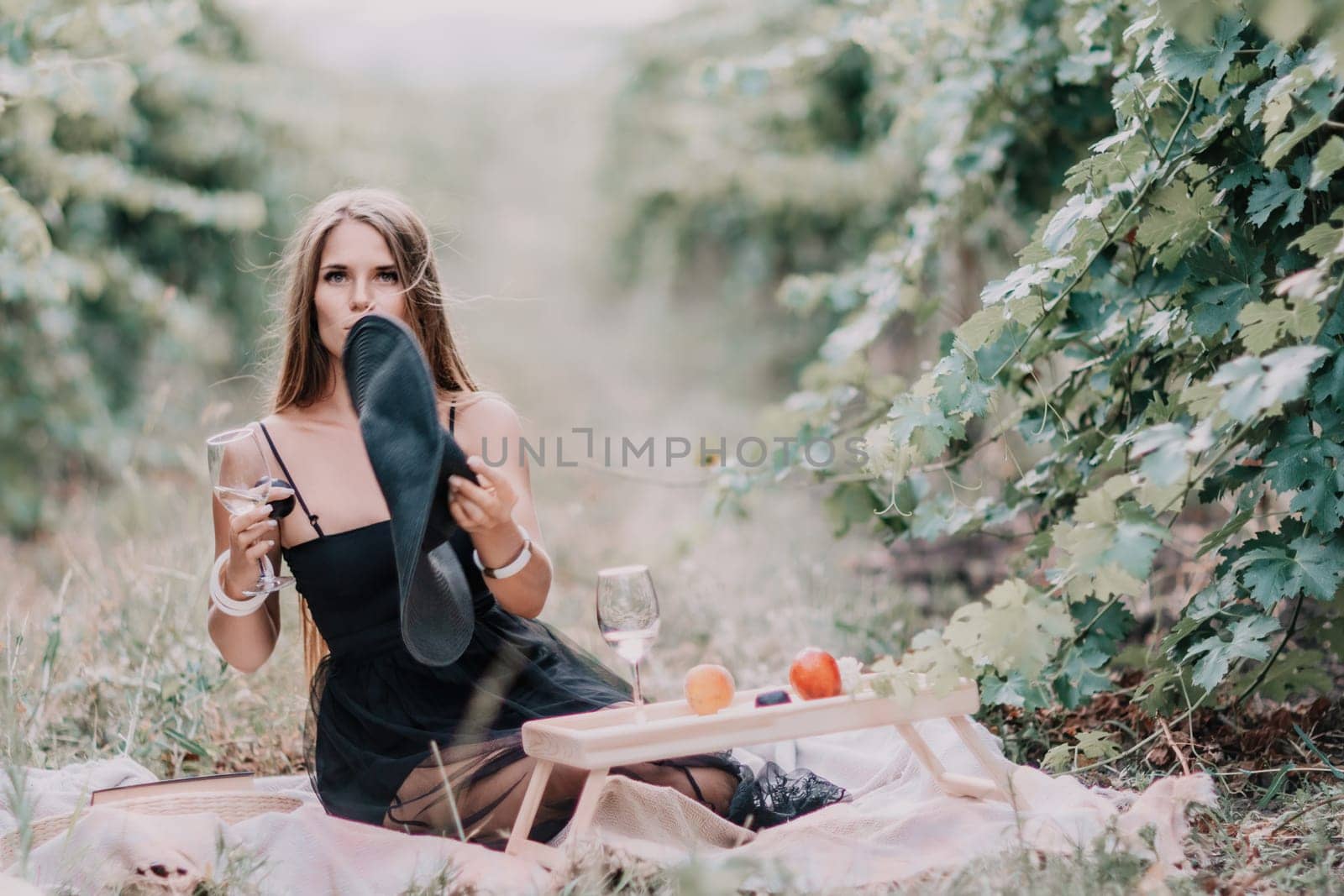 Picnic and wine tasting at sunset in the hills of Italy, Tuscany. Vineyards and open nature in the summer. Romantic dinner, fruit and wine.