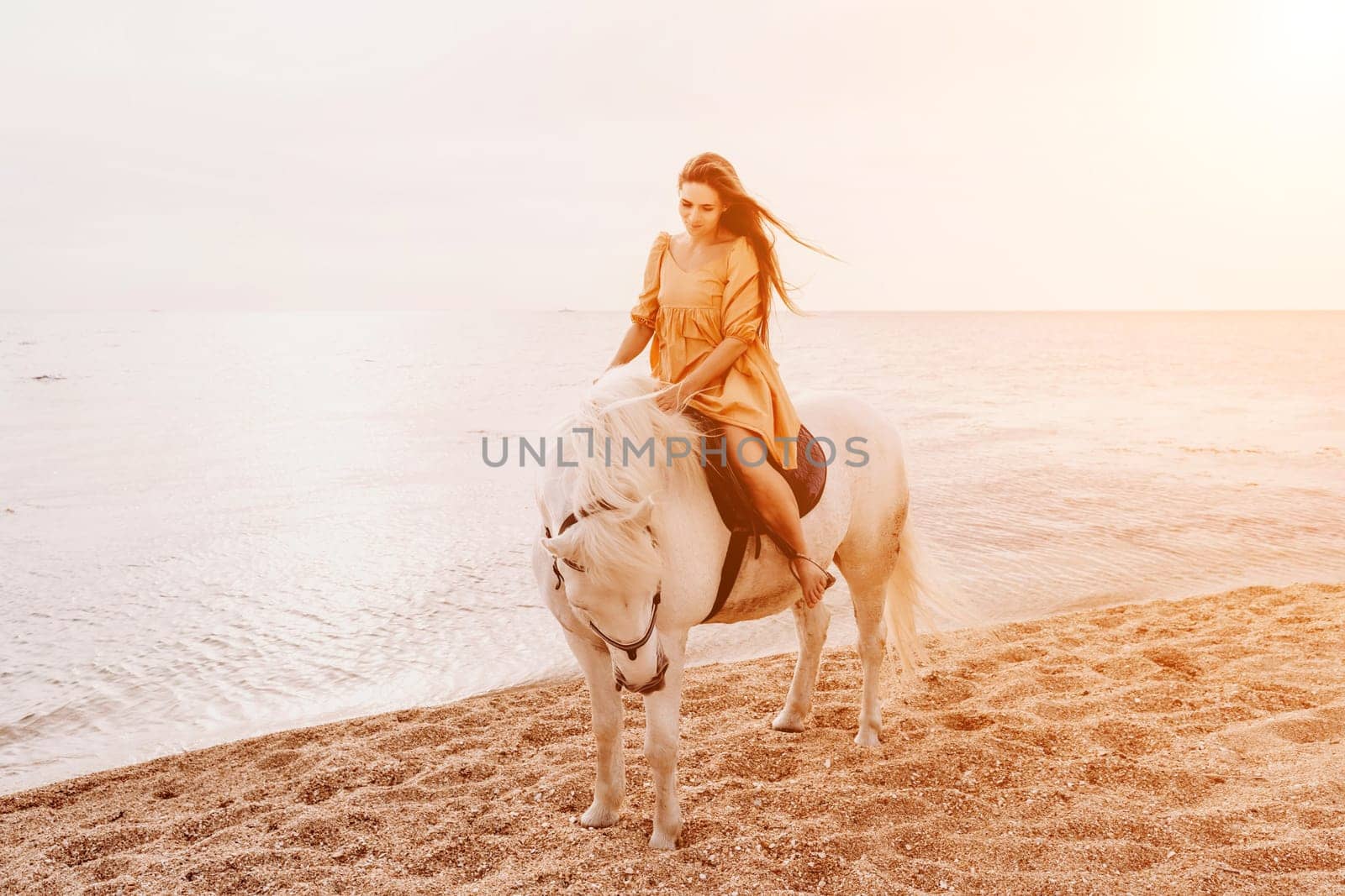 A woman in a dress stands next to a white horse on a beach, with the blue sky and sea in the background. by Matiunina