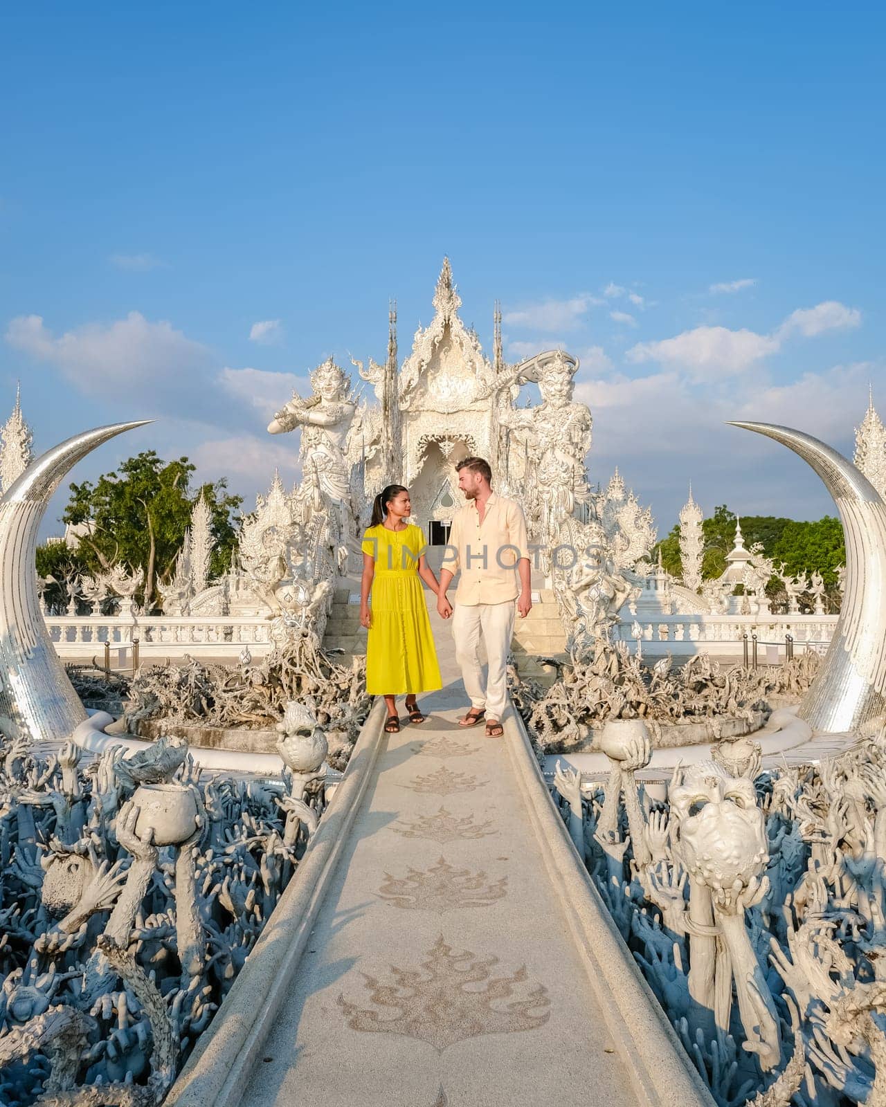 White Temple Chiang Rai Thailand, a diverse couple of men and women visit Wat Rong Khun temple in Northern Thailand.