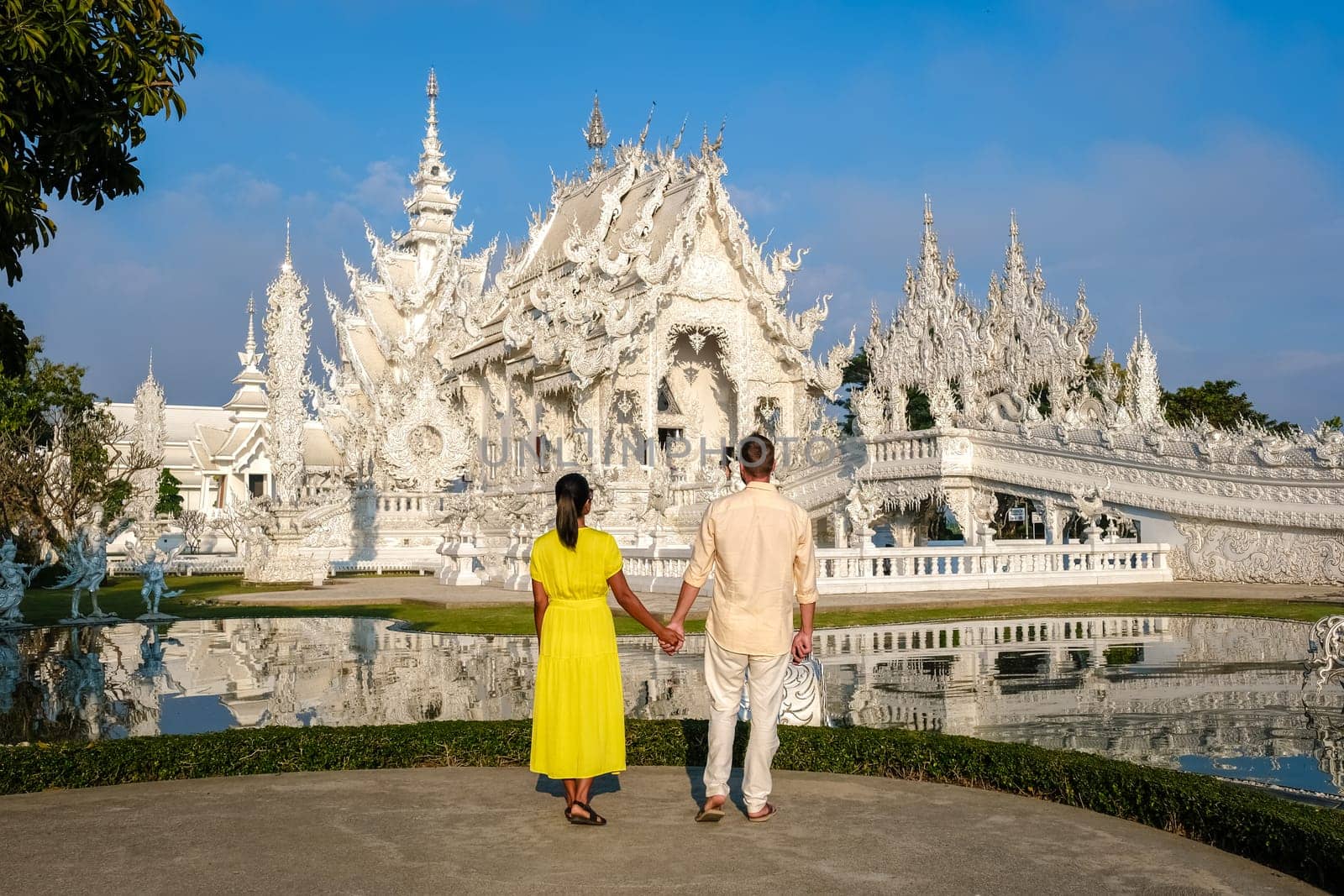 White Temple Chiang Rai Thailand, a diverse couple of European men and Asian women visit Wat Rong Khun temple, Northern Thailand.