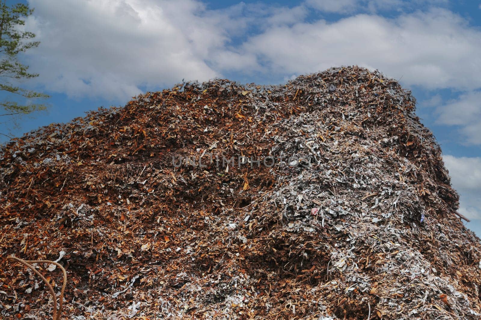 A large pile of rusty metal waste against the sky. Environment protection.