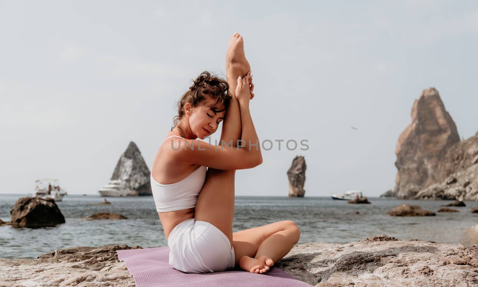 Fitness woman sea. Outdoor workout on yoga mat in park near to ocean beach. Female fitness pilates yoga routine concept. Healthy lifestyle. Happy fit woman exercising with rubber band in park.