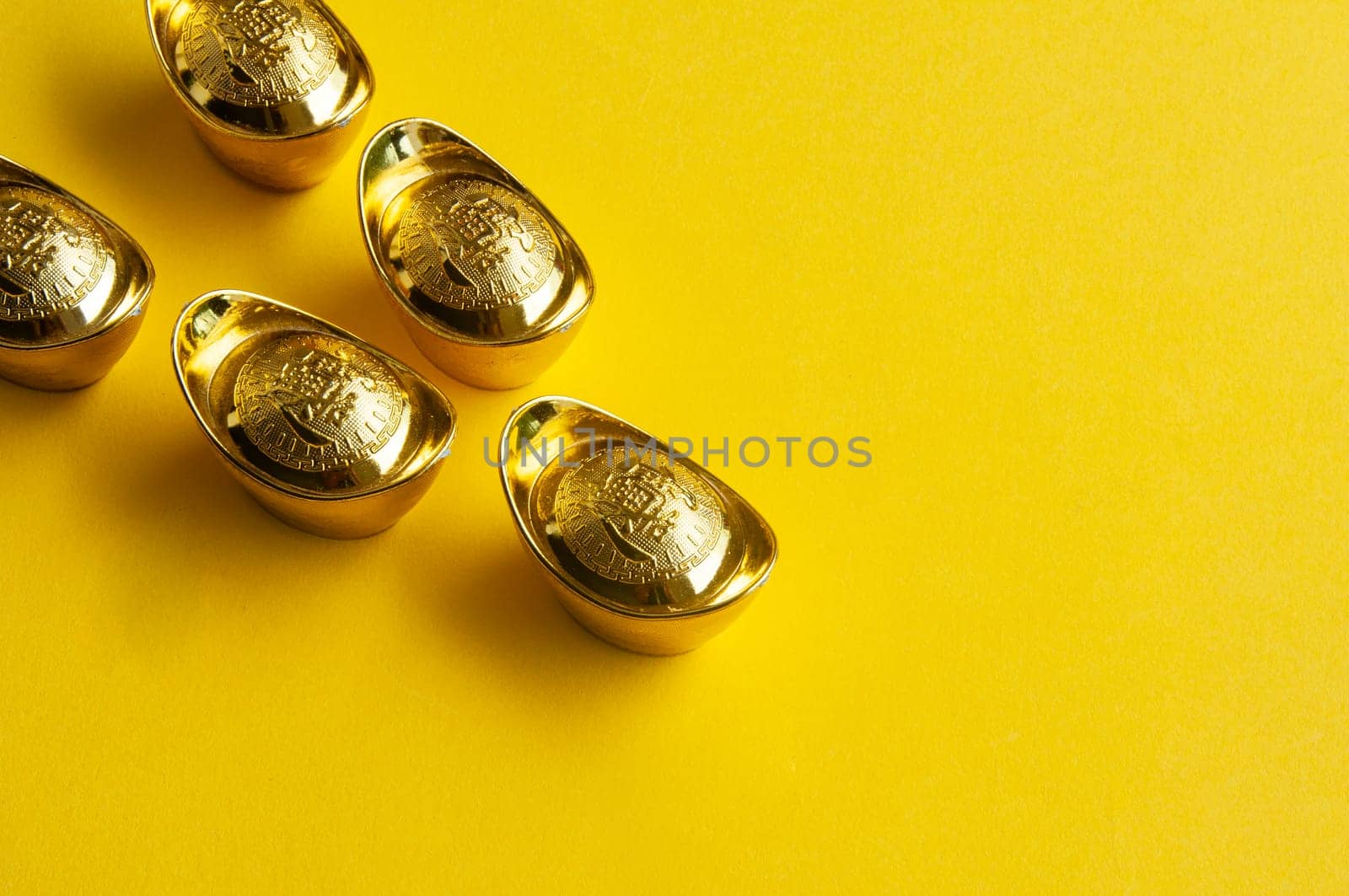 Top view of golden ingot on yellow cover background.