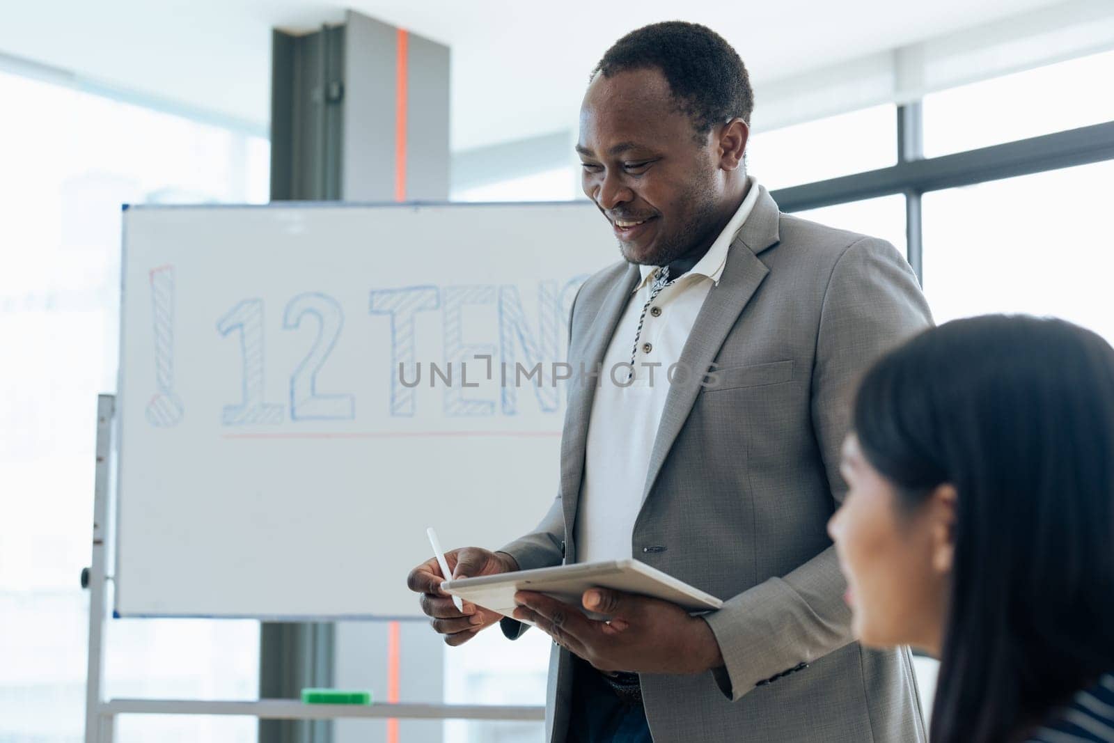 Mature african american professor talking to his student while teaching in class by itchaznong