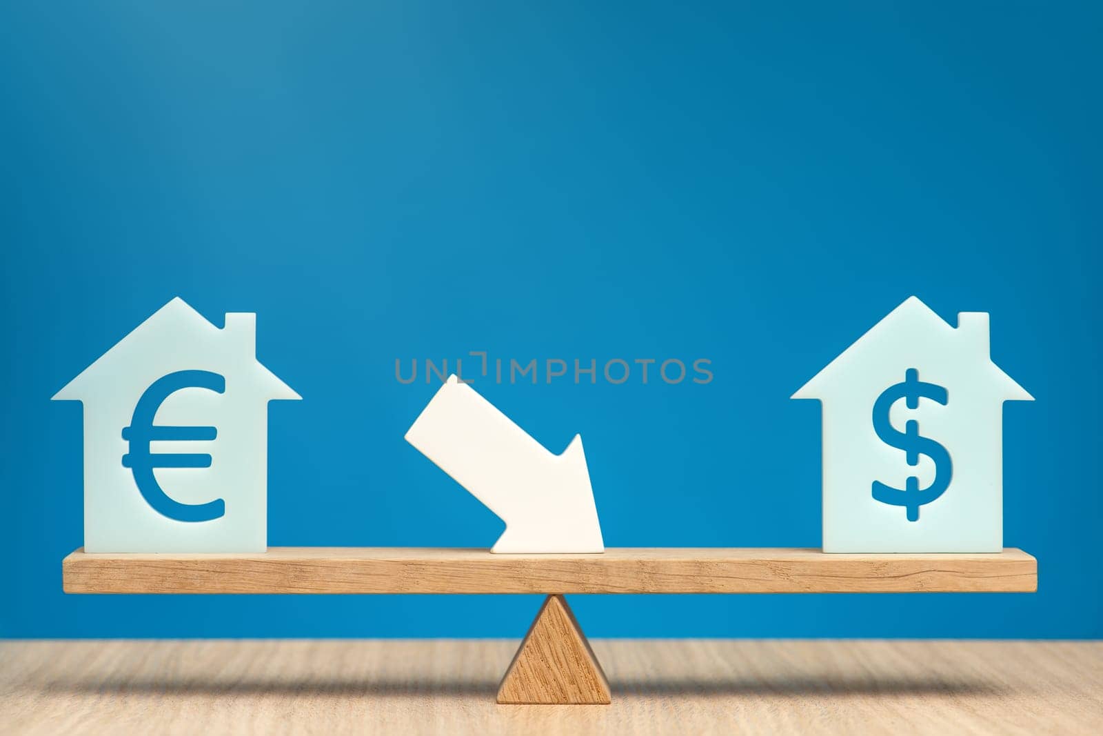 Reducing the cost of housing. House models with dollar and euro symbols stand in balance on a scale. Banner on the theme of real estate discounts on a blue background and a white arrow pointing down. by SERSOL