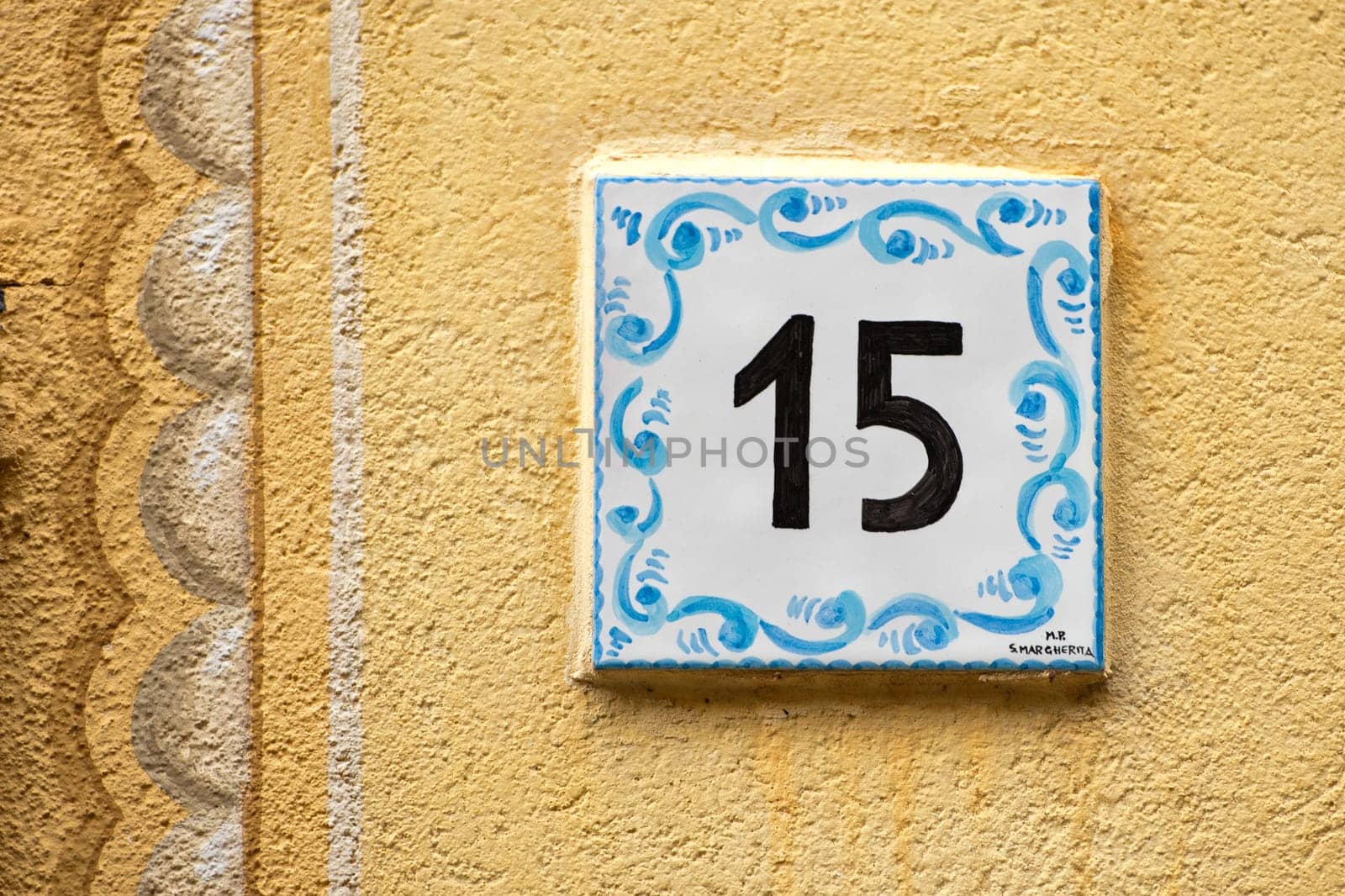 Ceramic number tile 15 on italian old house