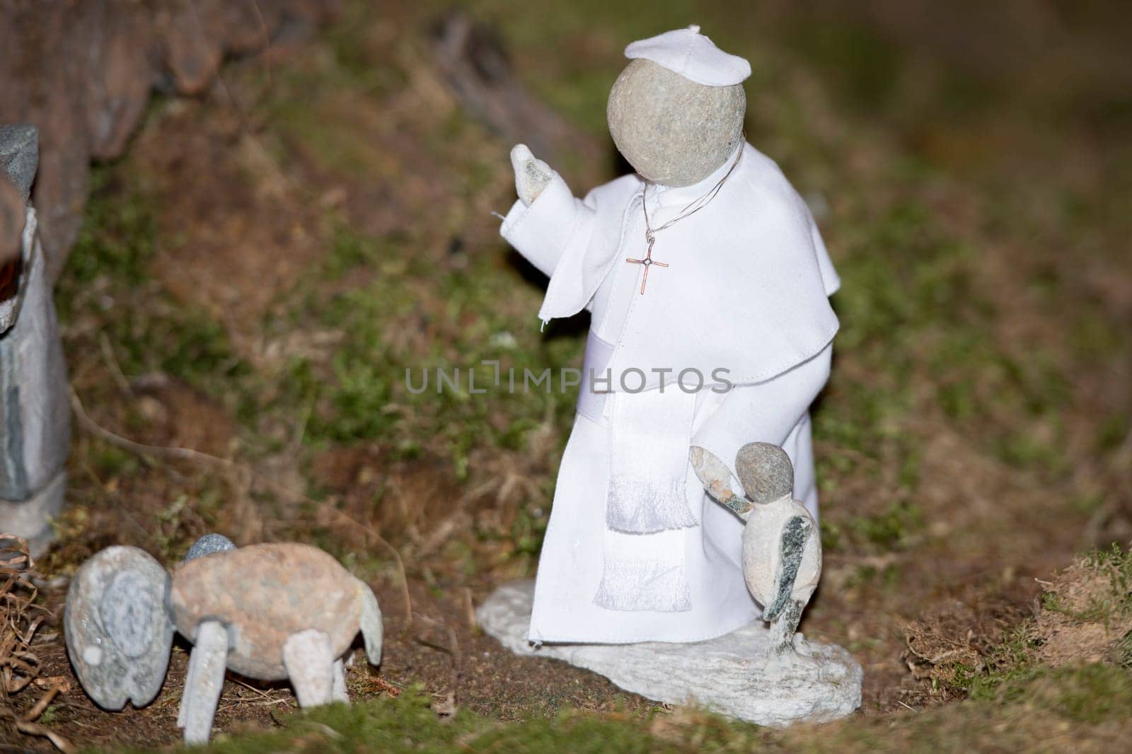 pope francis stone statue while holding children by hand