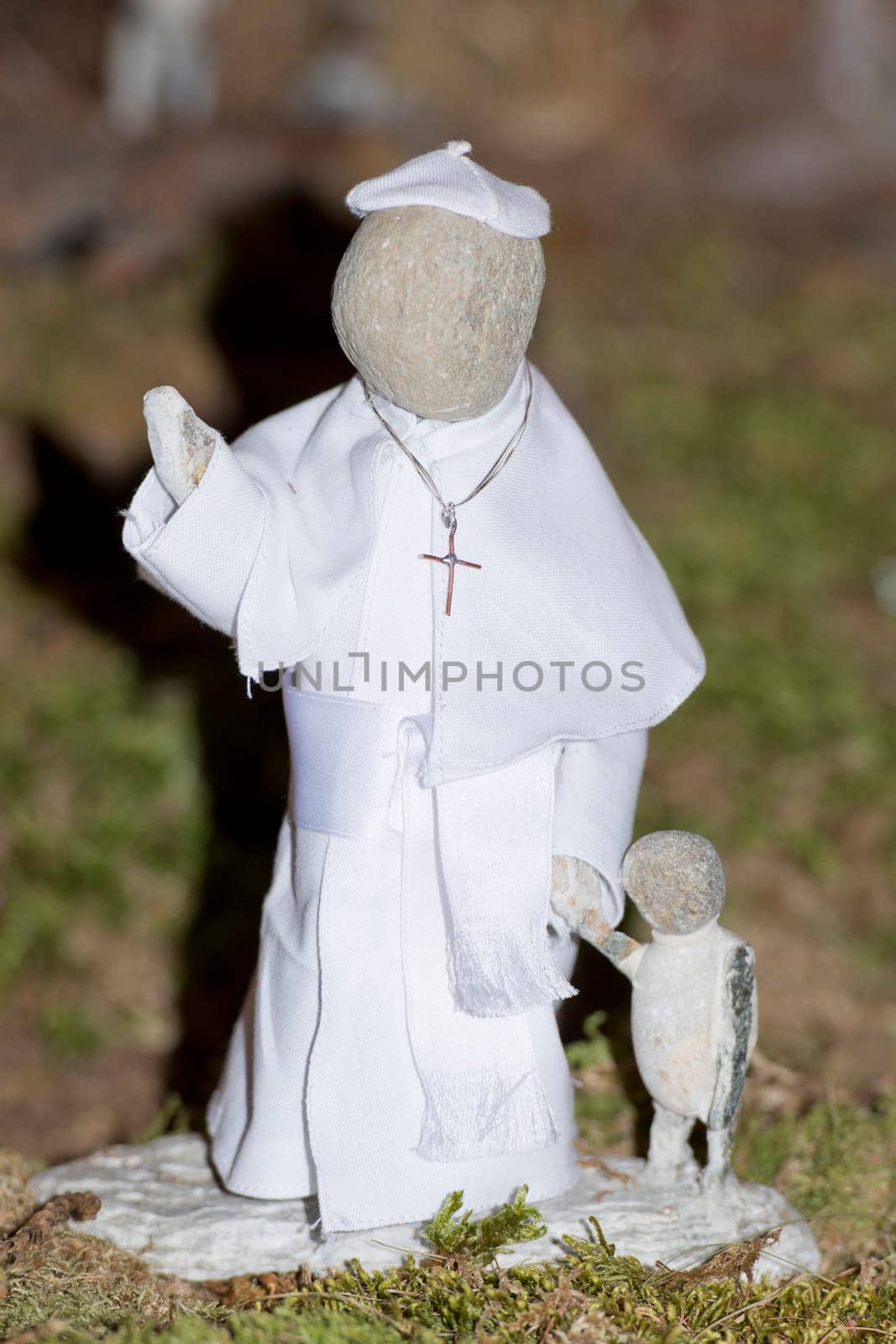 pope francis stone statue while holding children by hand